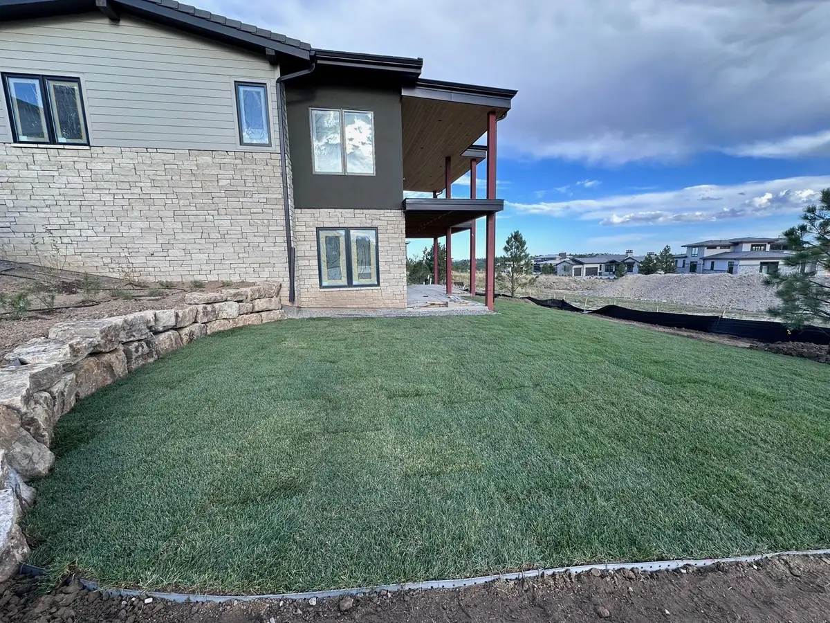 Fresh sod installation with stone retaining wall and lawn