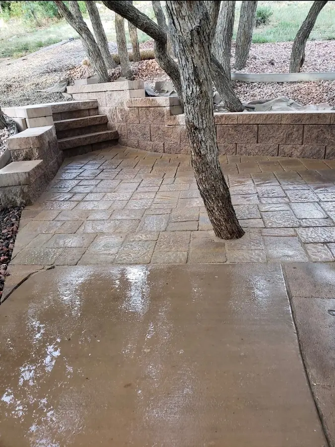 Stamped concrete patio with retaining wall and tree