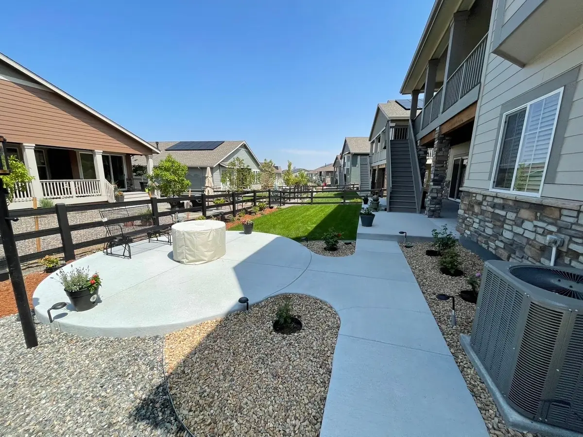 Backyard patio with curved walkway and fresh sod lawn