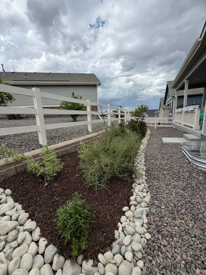 Side yard xeriscape with river rock border and native plants